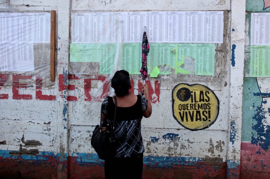 A woman checks her name on voting lists at a polling station during the municipal elections in Managua